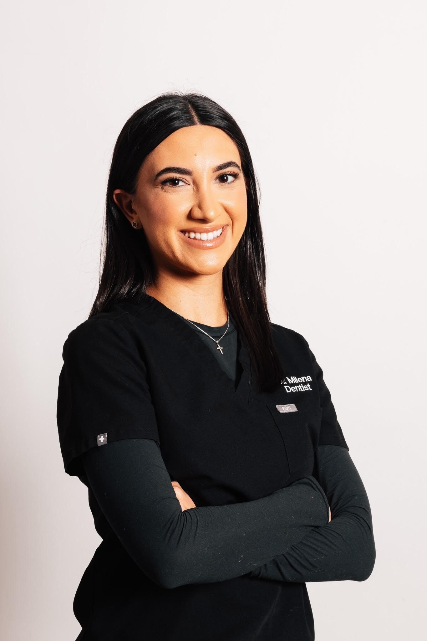 Dr. Milena Arakelyan, DMD, standing with arms crossed in black scrubs