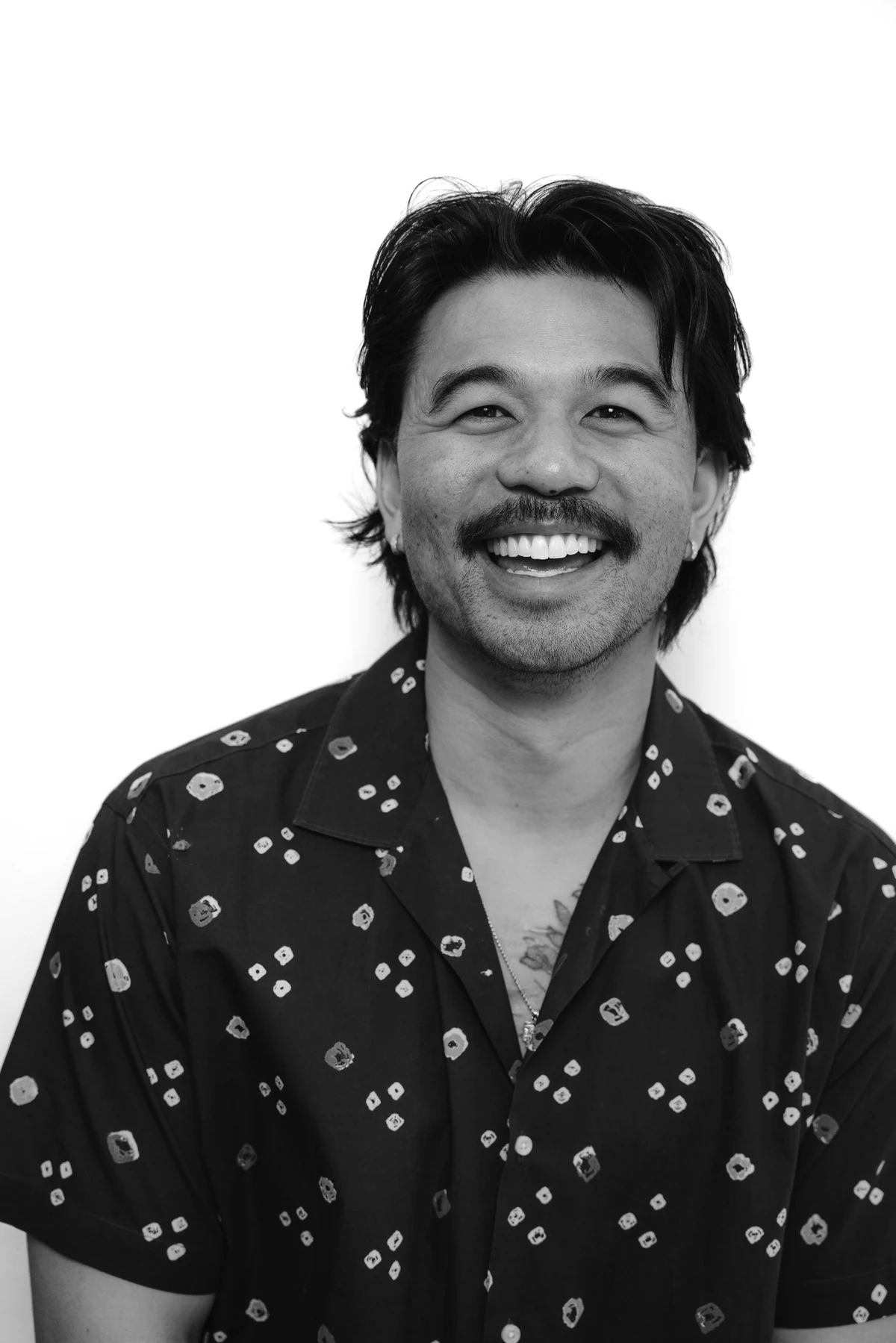 Black-and-white smiling portrait of Dr. Khoa Nguyen in a patterned shirt